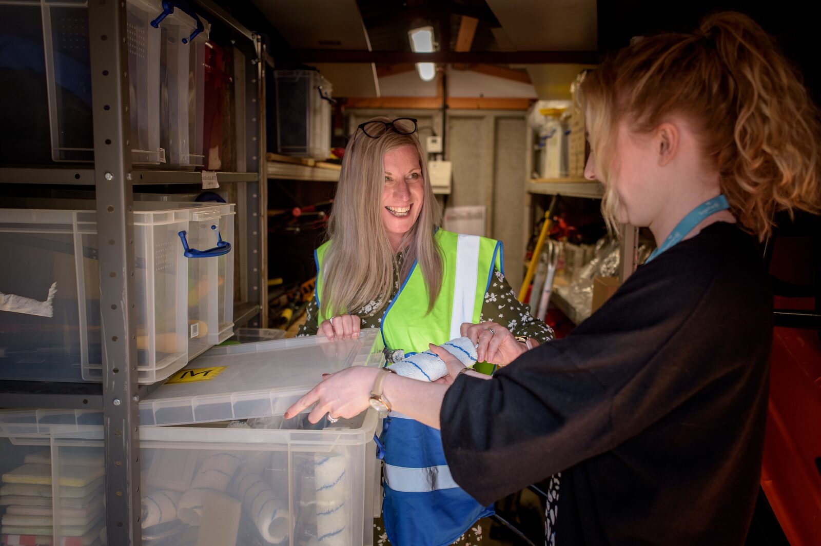 Two small-business coworkers organizing supplies in a warehouse.